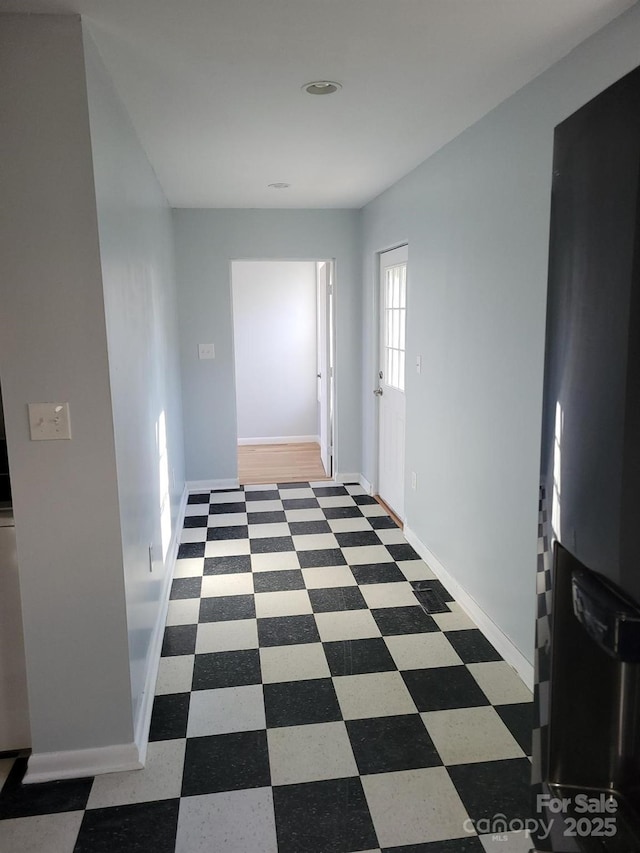 hallway featuring baseboards and tile patterned floors