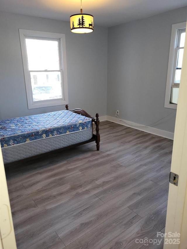 unfurnished bedroom with dark wood-type flooring and baseboards