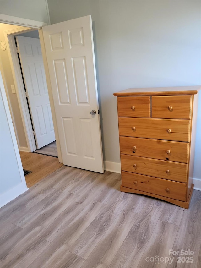 unfurnished bedroom featuring baseboards and light wood finished floors