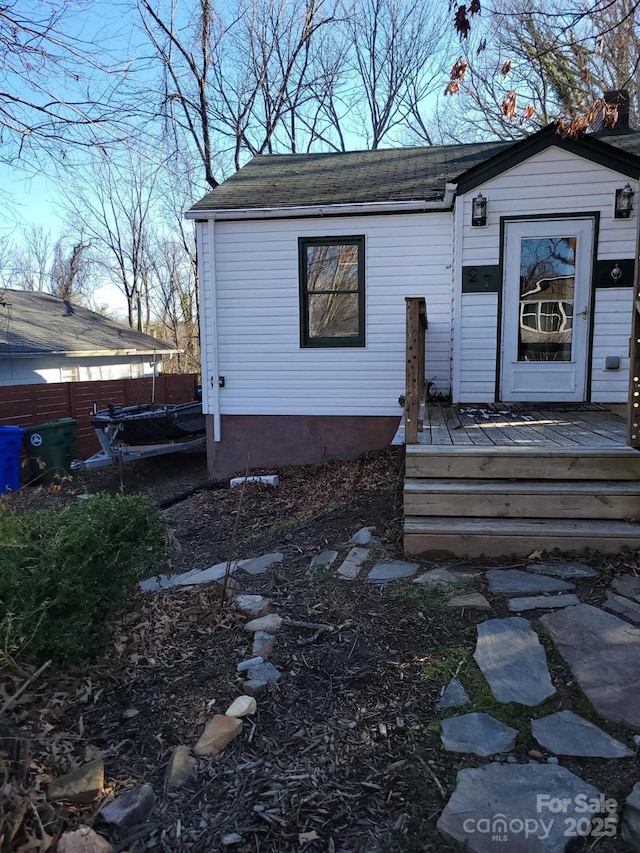 property entrance featuring fence and a wooden deck