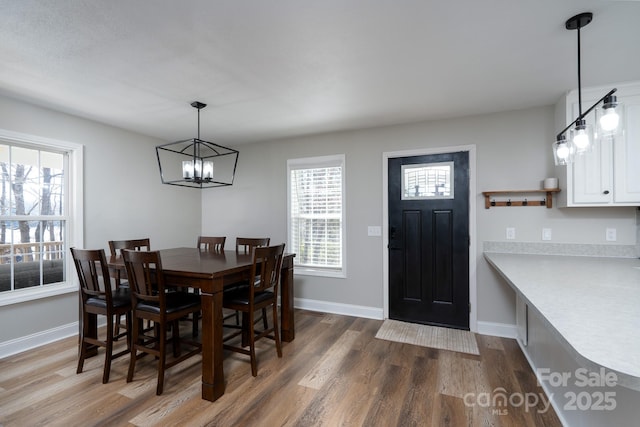 dining room with baseboards, a chandelier, and dark wood-type flooring