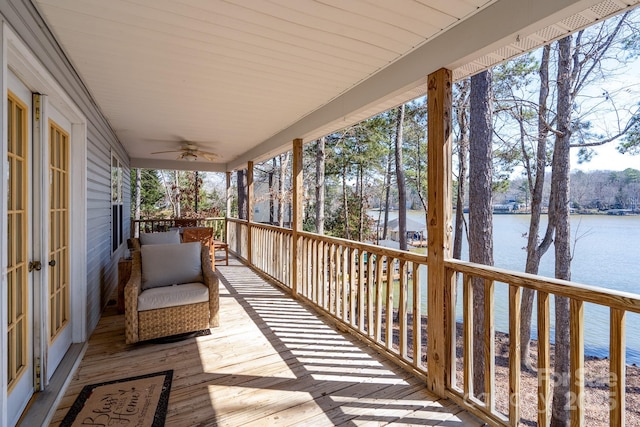 wooden deck featuring ceiling fan and a water view