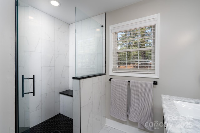 bathroom with recessed lighting, marble finish floor, tiled shower, and vanity