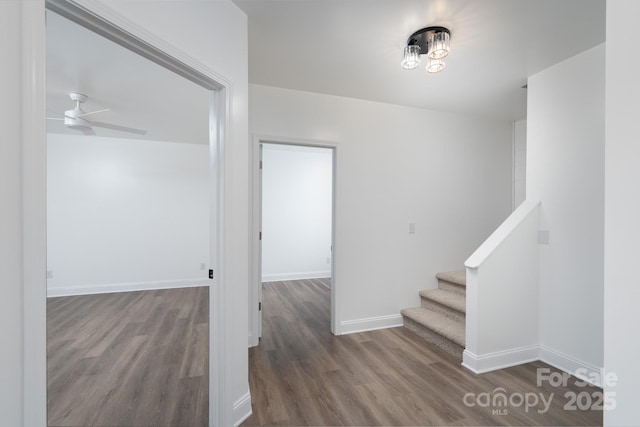 staircase featuring ceiling fan, baseboards, and wood finished floors