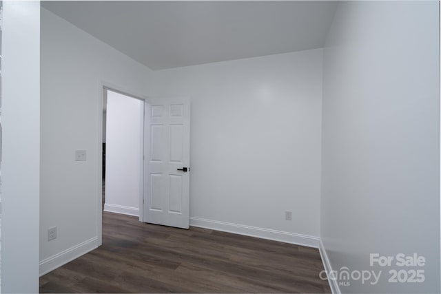 unfurnished room with dark wood-style floors and baseboards