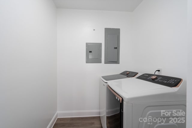 washroom featuring washing machine and dryer, laundry area, electric panel, and wood finished floors