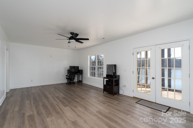 interior space featuring french doors, wood finished floors, a ceiling fan, and baseboards