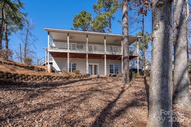 back of house featuring a ceiling fan and a wooden deck