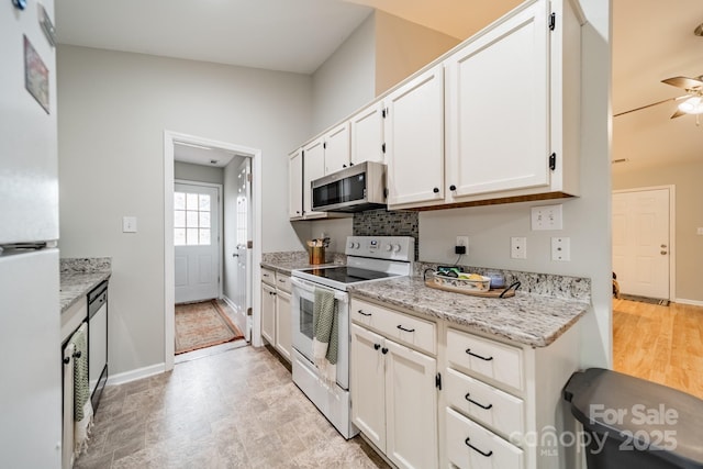 kitchen with white appliances, tasteful backsplash, a ceiling fan, light stone countertops, and white cabinetry