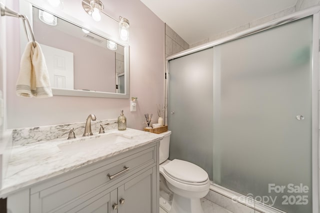 bathroom with visible vents, vanity, a shower stall, and toilet