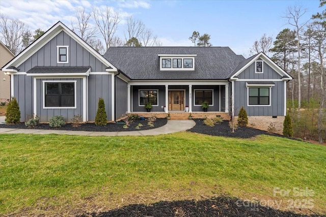 modern farmhouse featuring a front lawn, covered porch, board and batten siding, and a shingled roof