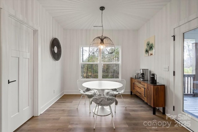 dining room with baseboards, an inviting chandelier, and wood finished floors