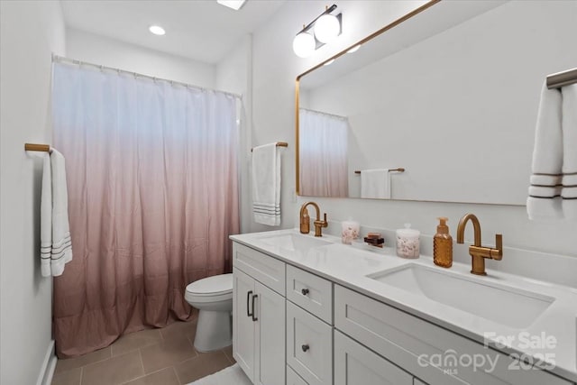 bathroom featuring a sink, toilet, double vanity, and tile patterned flooring