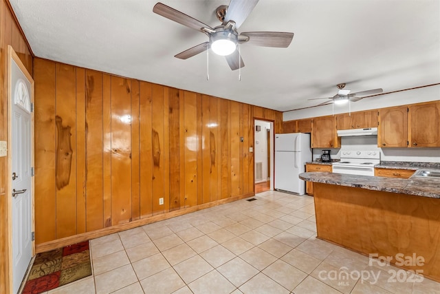 kitchen with white appliances, brown cabinetry, a sink, ceiling fan, and under cabinet range hood