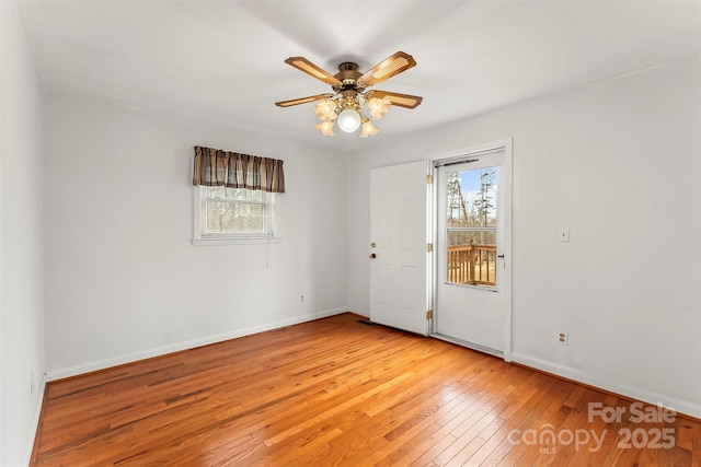 empty room with light wood-type flooring, baseboards, and a ceiling fan