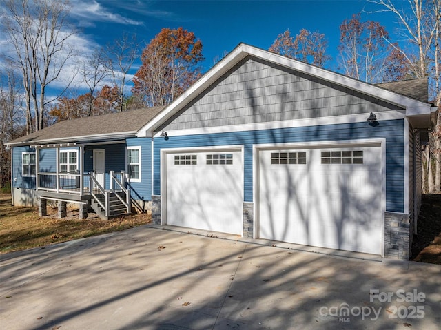 ranch-style home featuring covered porch, stone siding, and an attached garage