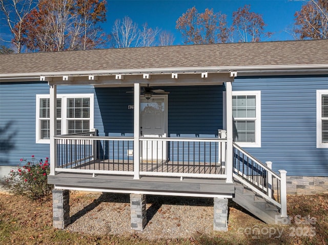 doorway to property with covered porch and roof with shingles