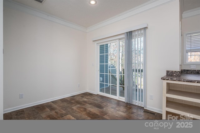 interior space with dark wood-style floors, visible vents, ornamental molding, a textured ceiling, and baseboards