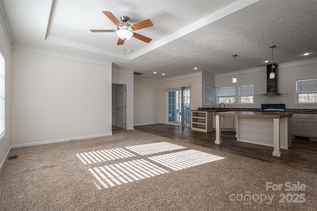 kitchen with plenty of natural light, wall chimney range hood, a kitchen bar, and stove