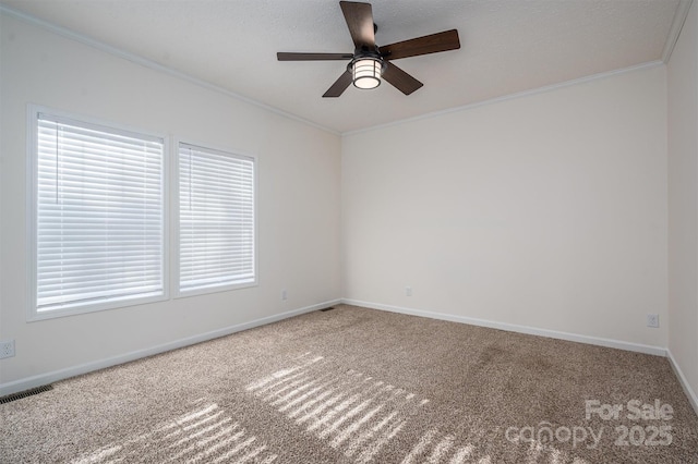 unfurnished room with crown molding, visible vents, carpet flooring, ceiling fan, and baseboards