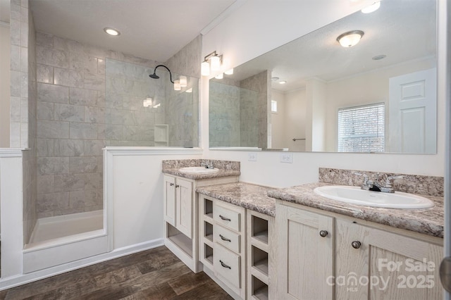 full bath featuring double vanity, ornamental molding, walk in shower, and a sink