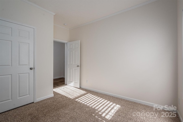 unfurnished bedroom with carpet floors, baseboards, and ornamental molding