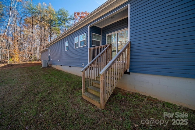 view of side of property featuring central AC, a yard, and crawl space