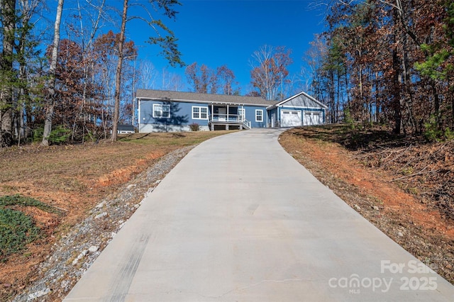 ranch-style house with covered porch, concrete driveway, and an attached garage