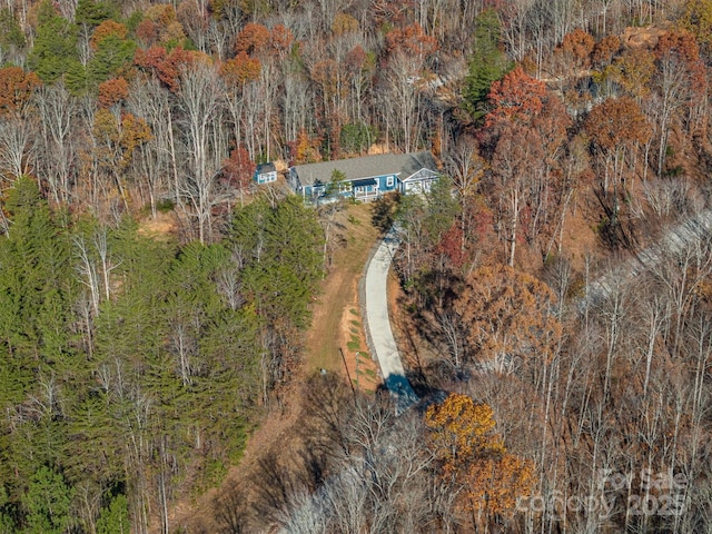 bird's eye view with a wooded view