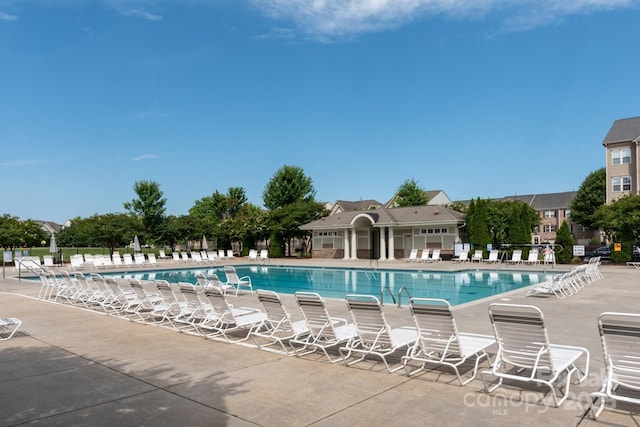 pool with a patio and fence