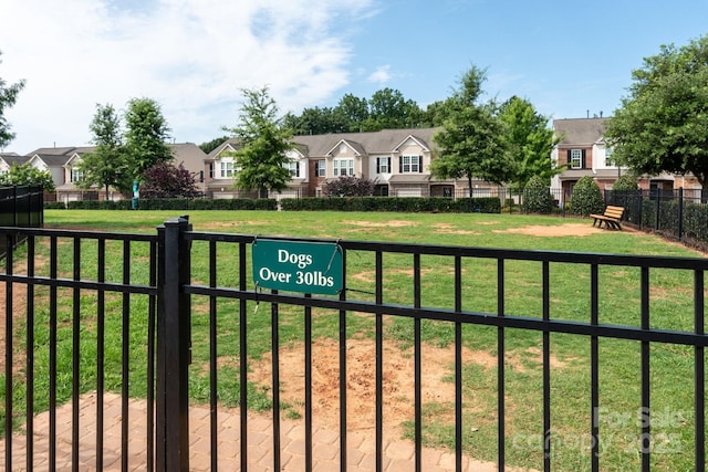 view of front of property featuring a residential view, a front lawn, and fence