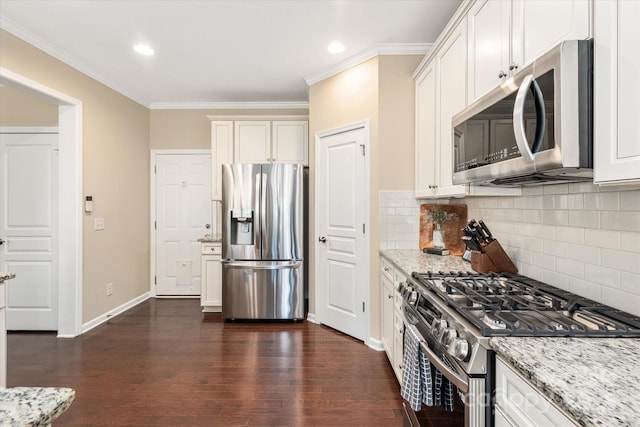 kitchen featuring dark wood-type flooring, ornamental molding, light stone countertops, and stainless steel appliances