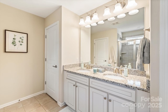 full bathroom featuring a sink, a stall shower, double vanity, and tile patterned flooring