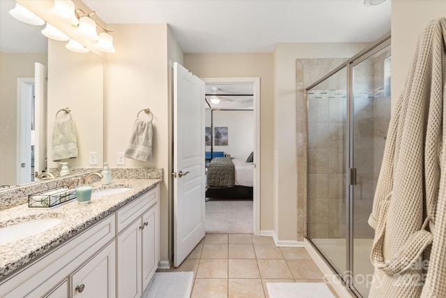 full bath with tile patterned floors, a stall shower, double vanity, and a sink