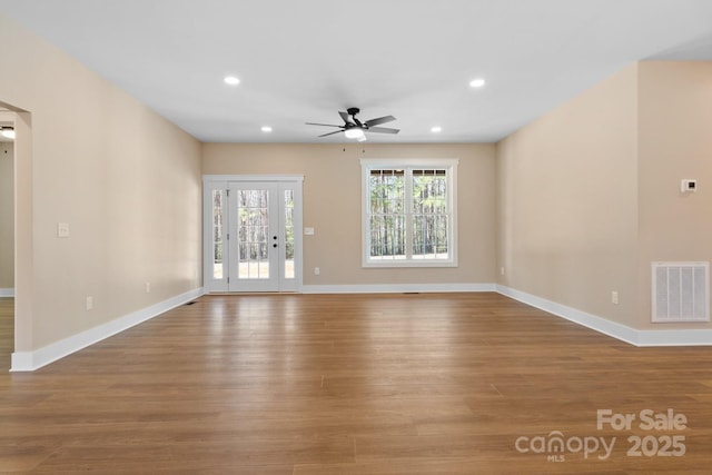 unfurnished living room featuring recessed lighting, wood finished floors, visible vents, and baseboards