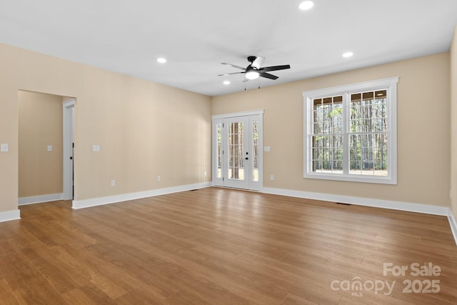 spare room with recessed lighting, baseboards, and wood finished floors