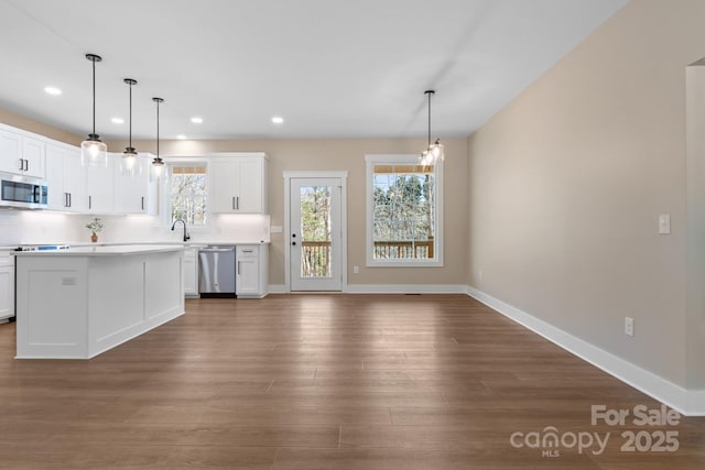 kitchen featuring a sink, white cabinets, dark wood-style flooring, and stainless steel appliances