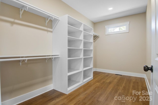 spacious closet featuring wood finished floors and visible vents