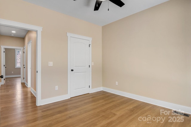 unfurnished bedroom with light wood-style flooring, visible vents, baseboards, and ceiling fan