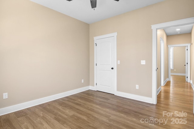 unfurnished bedroom featuring ceiling fan, baseboards, and wood finished floors