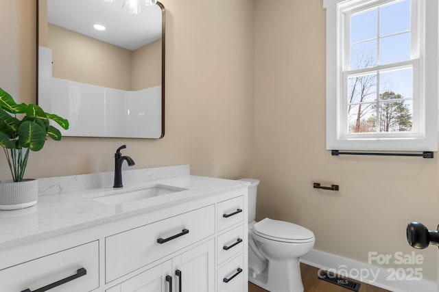 bathroom with visible vents, toilet, wood finished floors, baseboards, and vanity