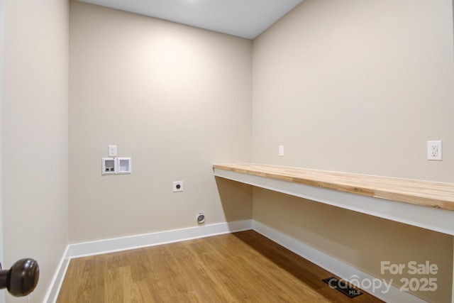 washroom featuring wood finished floors, baseboards, hookup for an electric dryer, hookup for a washing machine, and laundry area