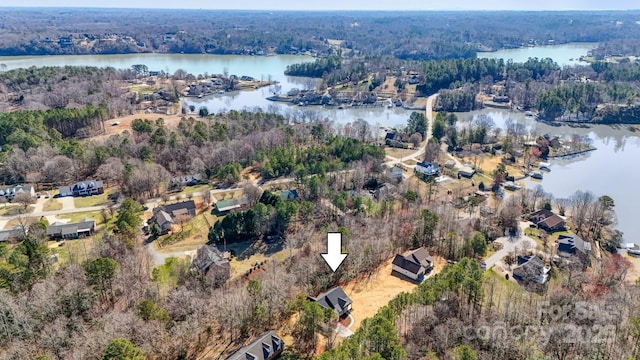 bird's eye view featuring a wooded view and a water view