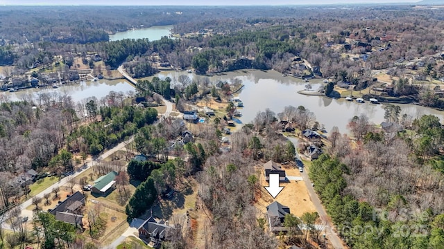 drone / aerial view featuring a water view and a view of trees