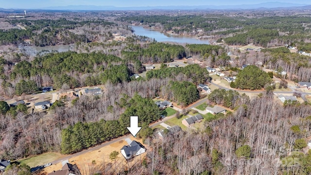 birds eye view of property with a view of trees and a water view