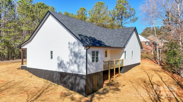 view of side of property with crawl space, driveway, and a shingled roof