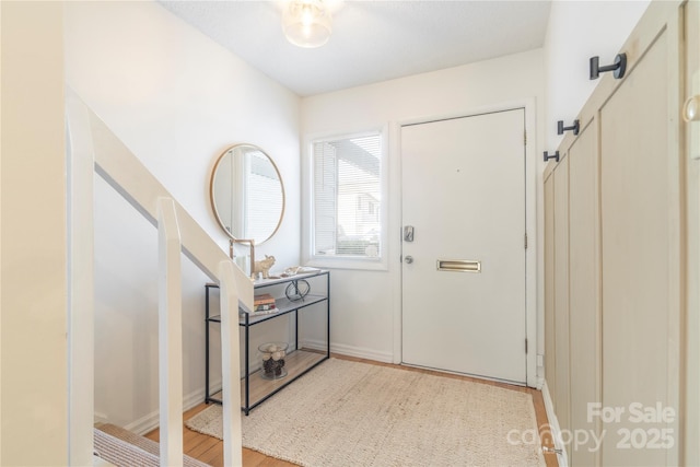 entrance foyer featuring baseboards and wood finished floors