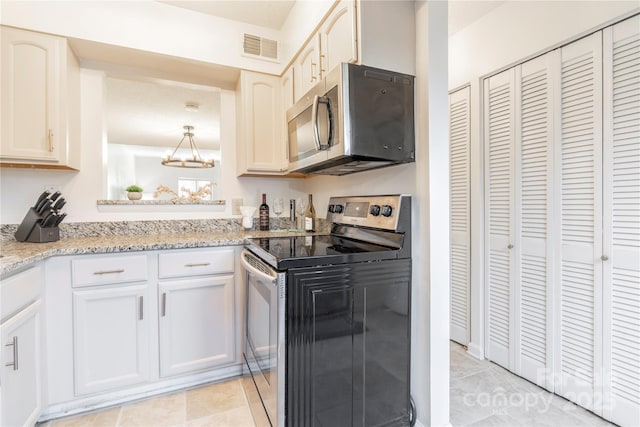 kitchen with appliances with stainless steel finishes, visible vents, light stone counters, and light tile patterned flooring