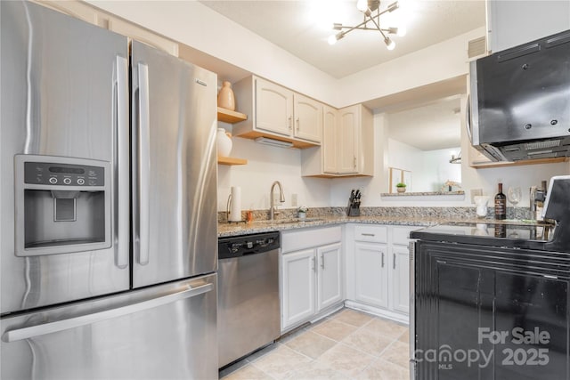 kitchen featuring open shelves, stainless steel appliances, a sink, light stone countertops, and a chandelier