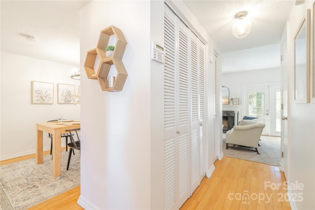 hall with light wood finished floors and baseboards